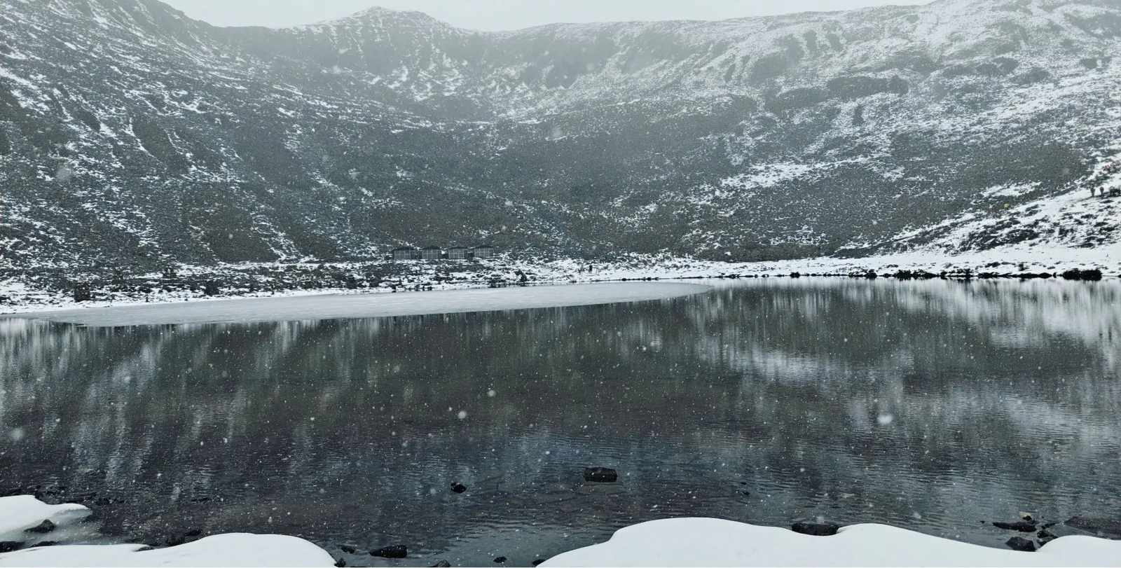 A lake under snowy slopes