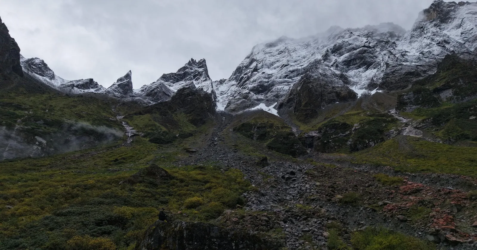 Snow peaks above a rock gully